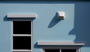 Houston house dryer vent with window on blue wall background